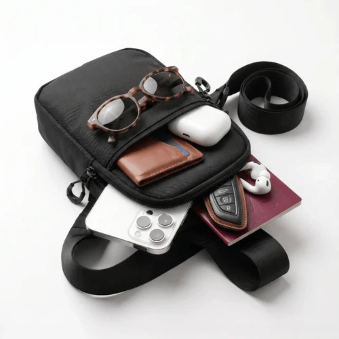 Bandolera abierta con movil, cartera, pasaporte y gafas de sol